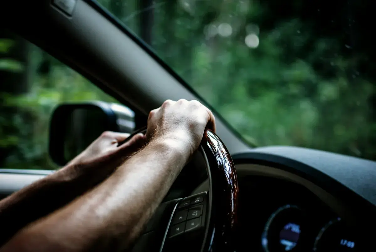 Mãos ao volante de um carro. Imagem ilustrativa.