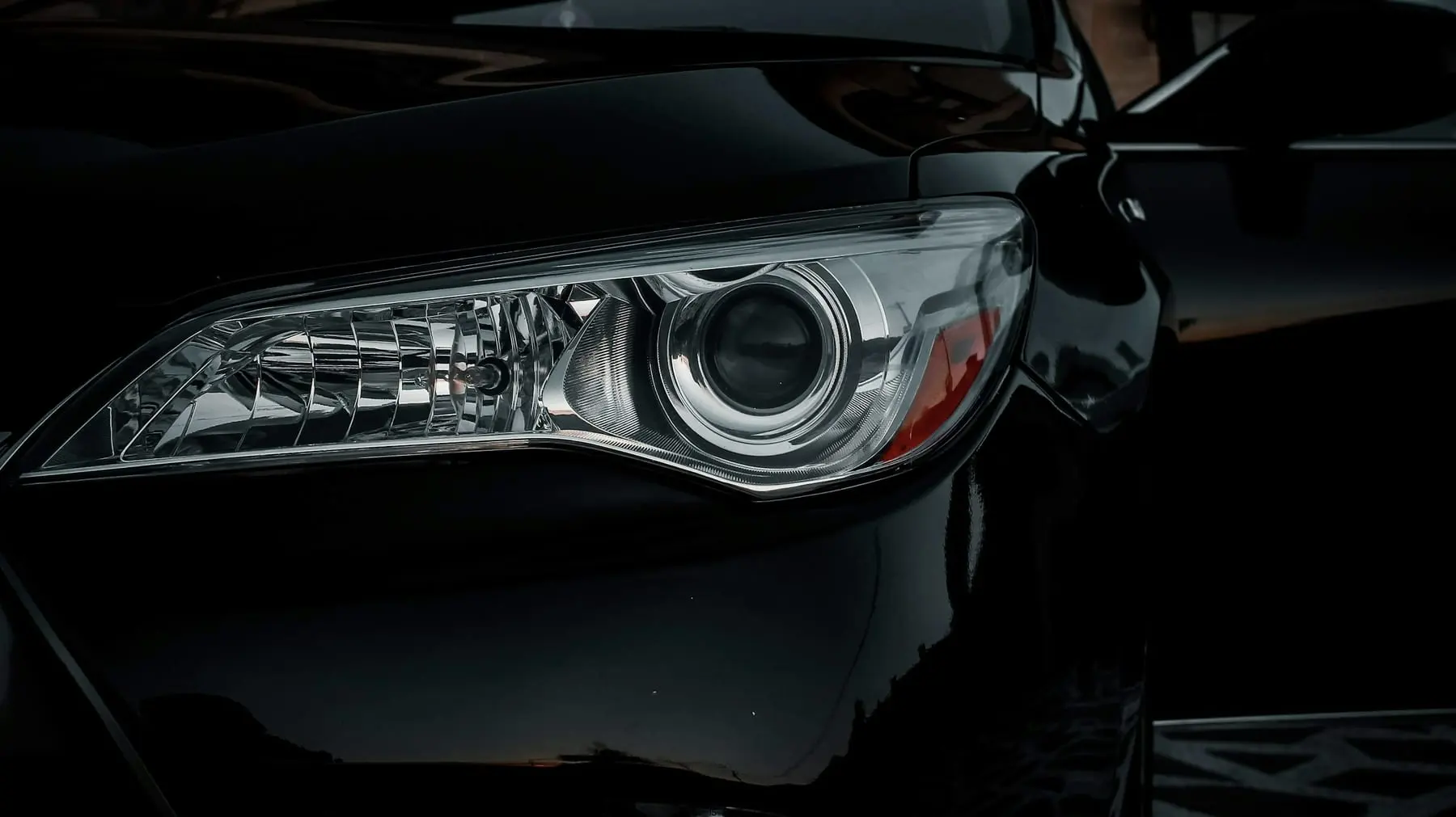 Farol de um carro preto em close. Imagem ilustrativa.